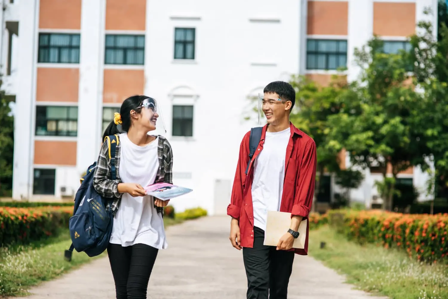 two students coming out of school and laughing